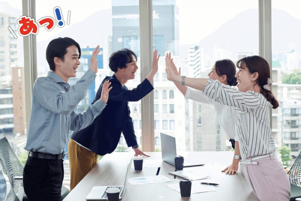 社内チームでナゾトキをしてハイタッチしている4人